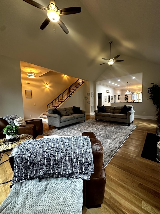 living room featuring ceiling fan, hardwood / wood-style floors, and lofted ceiling