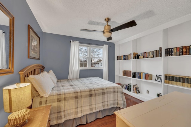 bedroom featuring ceiling fan, a textured ceiling, and hardwood / wood-style flooring