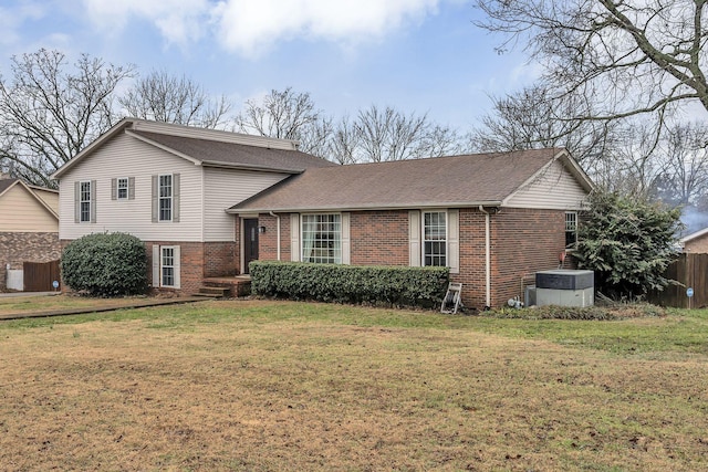 tri-level home with central AC unit and a front lawn