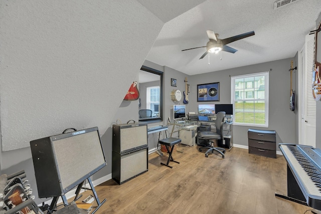 office with light hardwood / wood-style floors, a textured ceiling, and ceiling fan