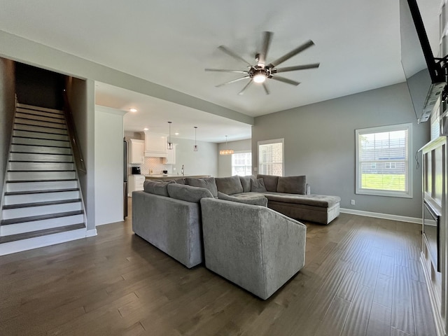 living room featuring ceiling fan, sink, and dark hardwood / wood-style flooring