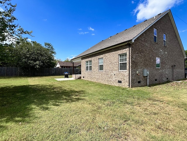 rear view of house with a lawn and a patio