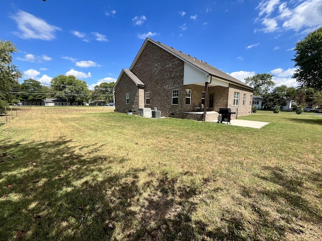 rear view of house featuring a yard, central AC unit, and a patio