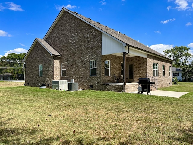 rear view of house featuring cooling unit, a yard, and a patio