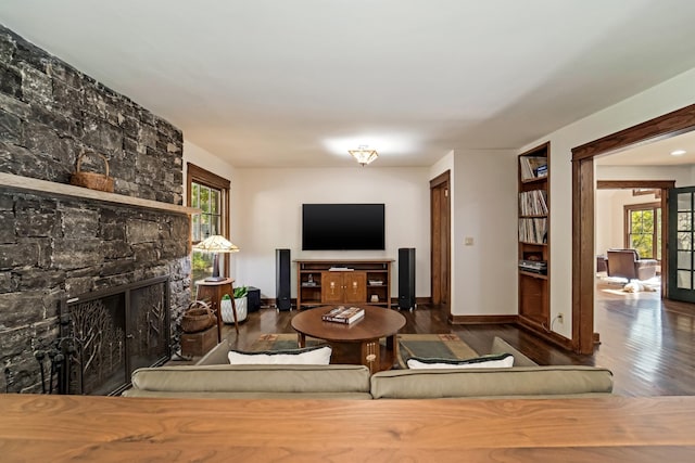 living room featuring a fireplace, dark wood-type flooring, and french doors