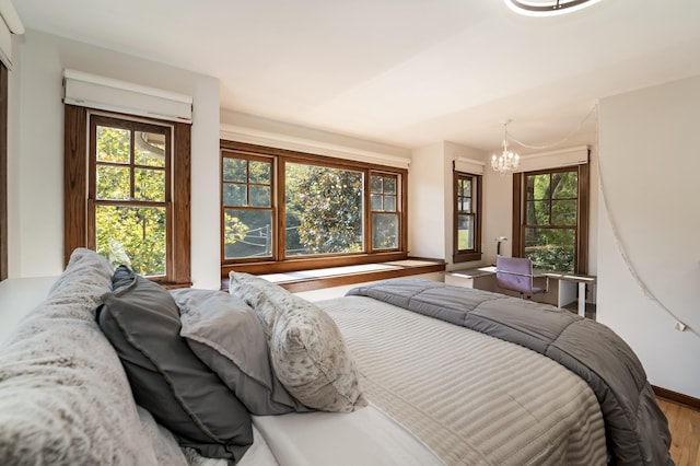 bedroom featuring an inviting chandelier and wood-type flooring