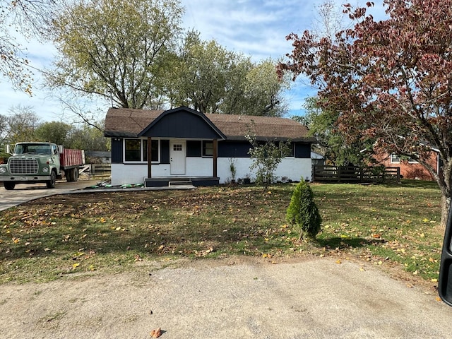 single story home featuring covered porch and a front lawn