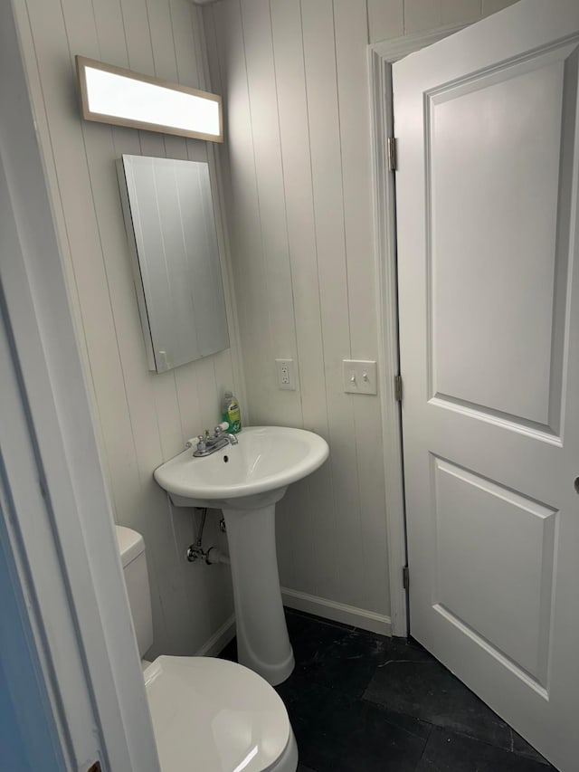 bathroom with wooden walls and toilet