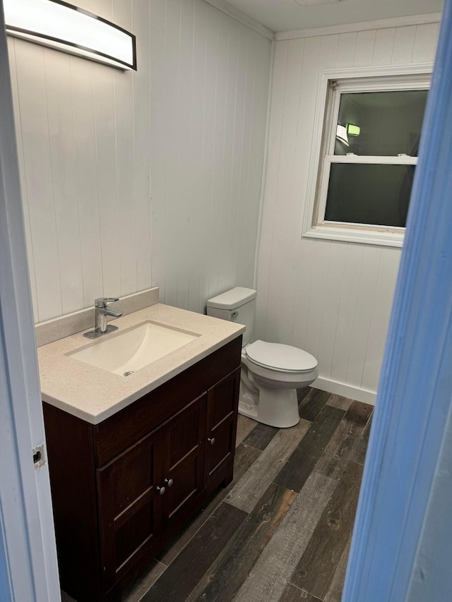 bathroom with vanity, toilet, and wood-type flooring