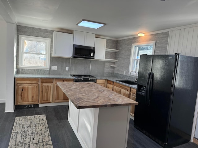 kitchen featuring sink, white cabinetry, a center island, wood counters, and black refrigerator with ice dispenser