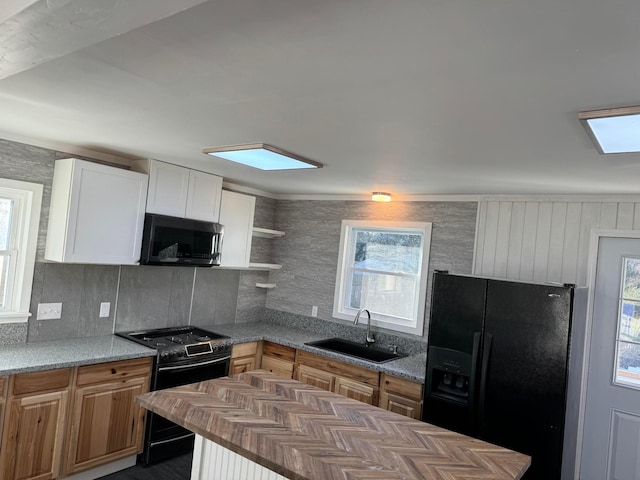 kitchen with black appliances, decorative backsplash, white cabinets, sink, and wood counters