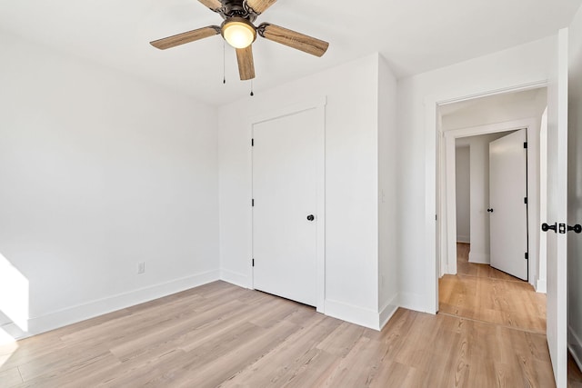 unfurnished bedroom with light hardwood / wood-style flooring, a closet, and ceiling fan