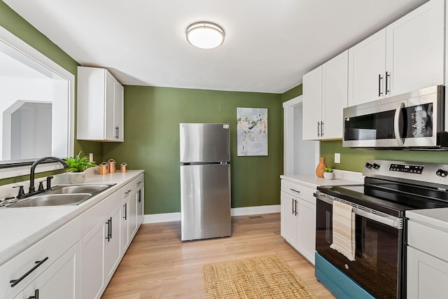 kitchen with white cabinetry, appliances with stainless steel finishes, and sink