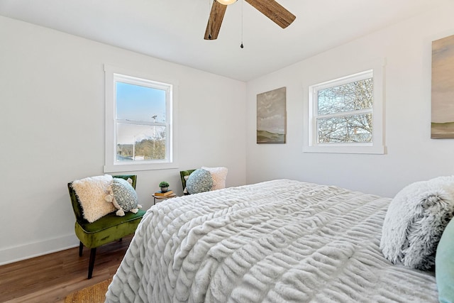 bedroom featuring multiple windows, hardwood / wood-style flooring, and ceiling fan