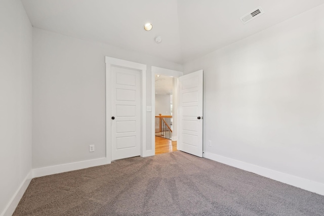 carpeted empty room with baseboards, visible vents, and recessed lighting