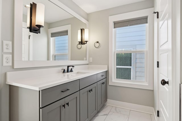 bathroom featuring marble finish floor, vanity, and baseboards