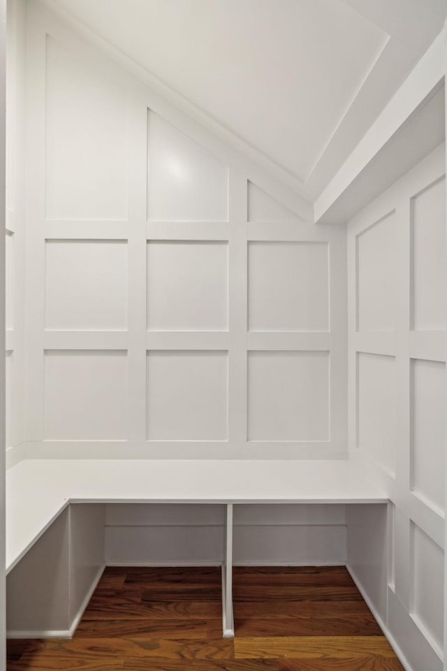 mudroom featuring lofted ceiling, a decorative wall, and wood finished floors