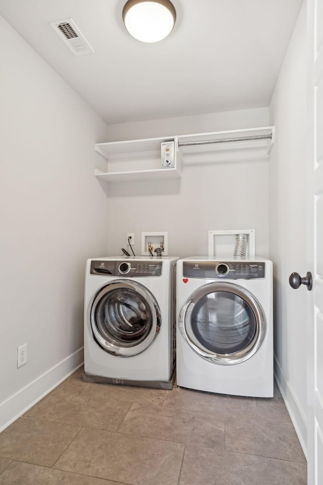 laundry area with washing machine and dryer, laundry area, visible vents, and baseboards