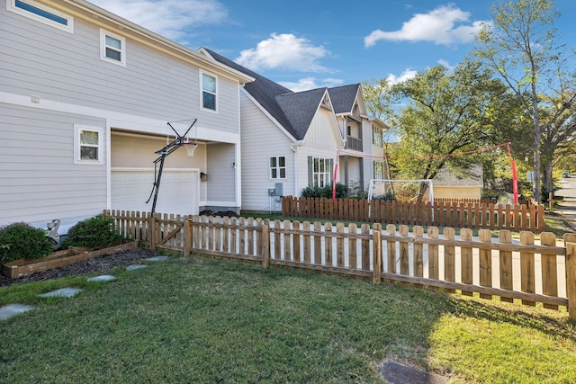 view of property exterior with a garage, a yard, a shingled roof, and a fenced front yard