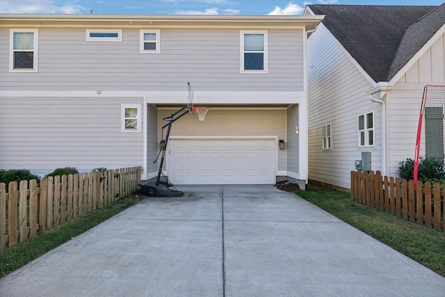 view of front of house featuring a garage, driveway, and fence