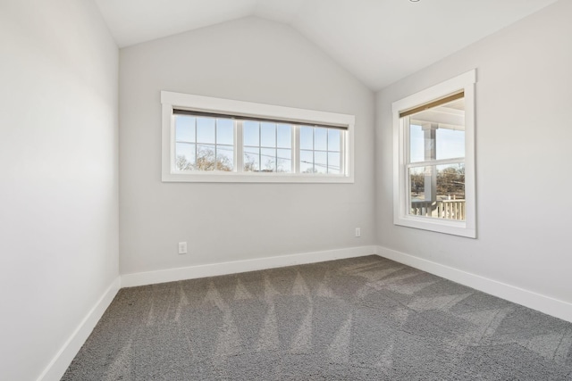 empty room featuring lofted ceiling, carpet, and baseboards