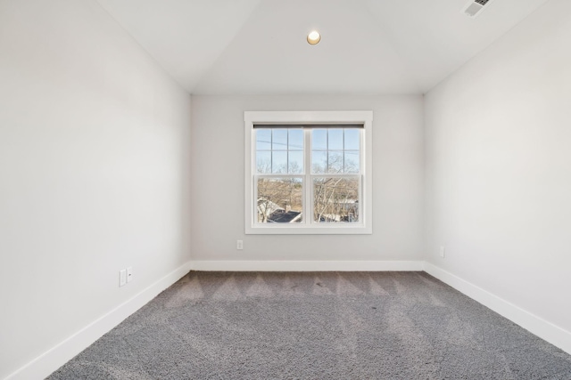 empty room featuring visible vents, baseboards, vaulted ceiling, and carpet flooring