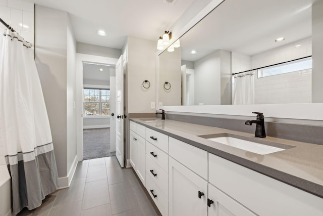 bathroom with tile patterned flooring, a sink, recessed lighting, and double vanity