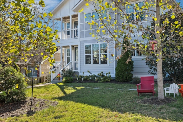 view of home's exterior with a yard, board and batten siding, fence, and a balcony