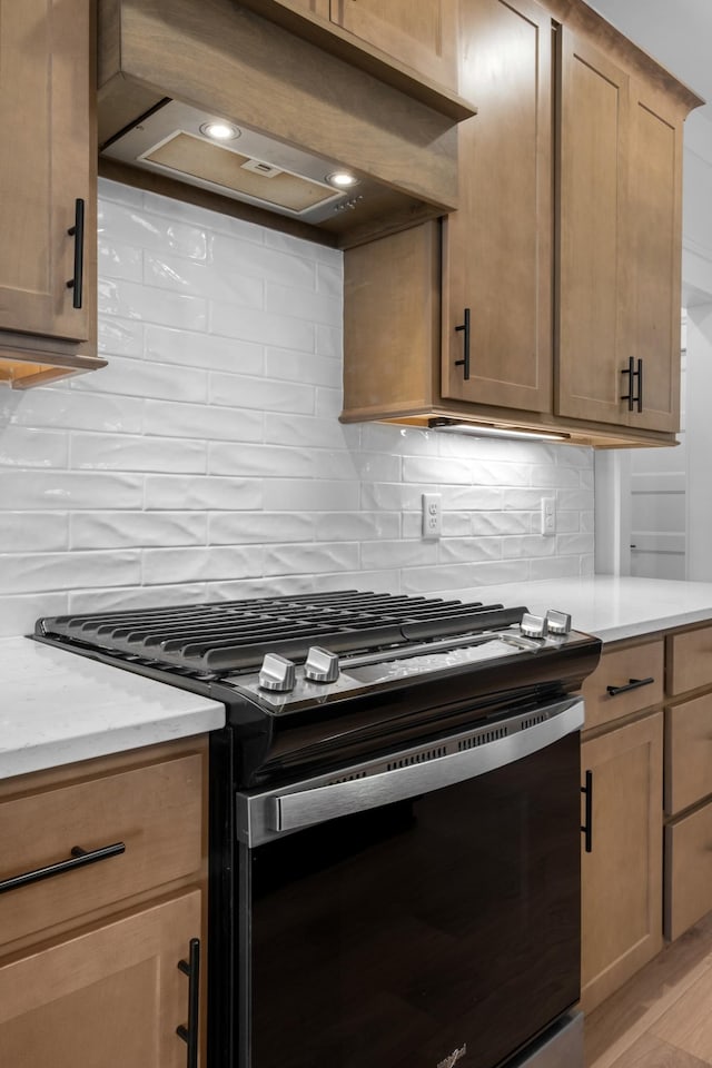 kitchen with stainless steel gas stove, premium range hood, and backsplash