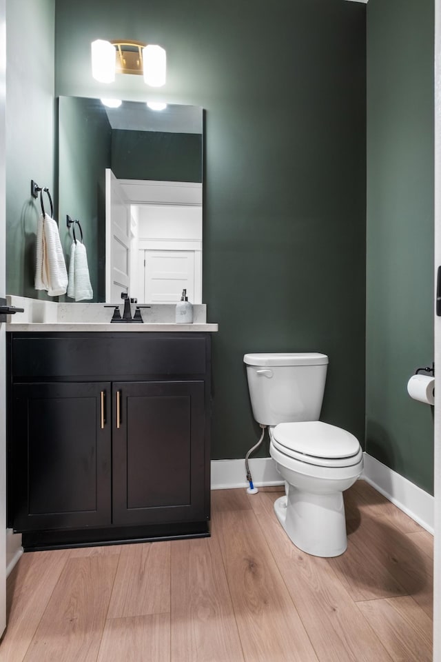 bathroom featuring vanity, toilet, and hardwood / wood-style flooring