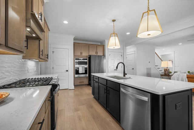 kitchen with decorative backsplash, sink, pendant lighting, an island with sink, and stainless steel appliances