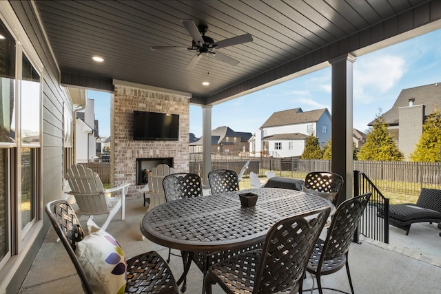 view of patio / terrace featuring ceiling fan and an outdoor brick fireplace