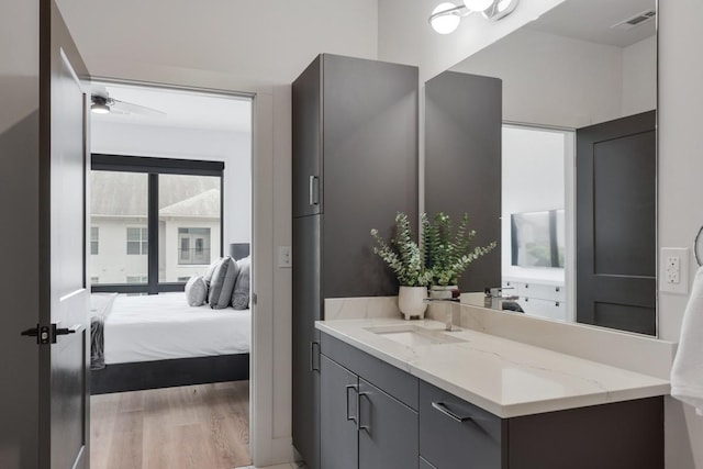 bathroom with hardwood / wood-style flooring, ceiling fan, and vanity