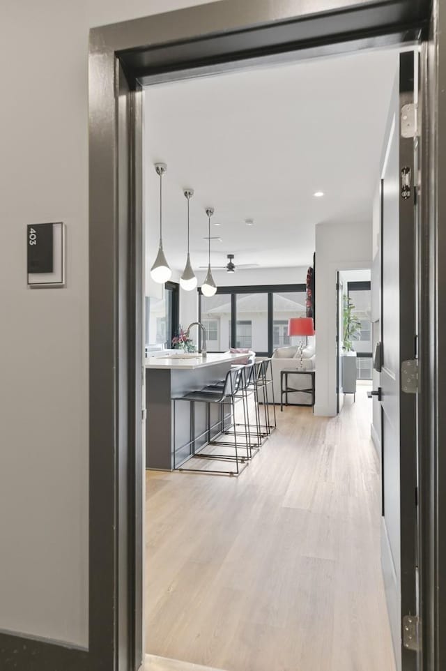 kitchen featuring a breakfast bar, pendant lighting, and light wood-type flooring