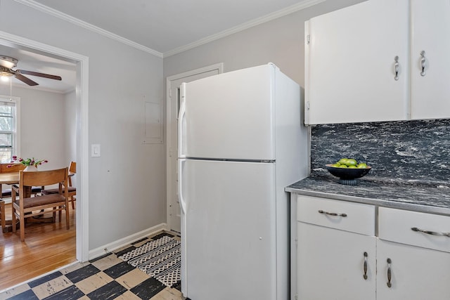 kitchen featuring crown molding, ceiling fan, white refrigerator, white cabinetry, and decorative backsplash