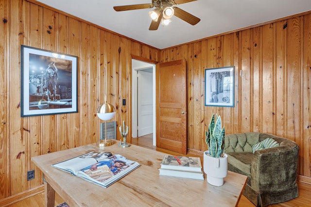 office area with wood-type flooring, wooden walls, and ceiling fan