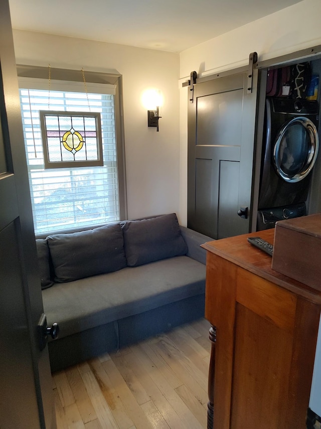 living room with a barn door, light hardwood / wood-style flooring, and washer / clothes dryer