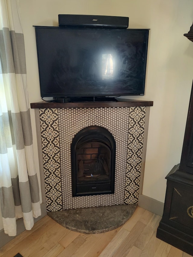 interior details with hardwood / wood-style floors and a wood stove