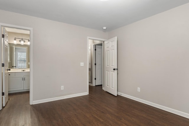 unfurnished bedroom with dark wood-type flooring and ensuite bath