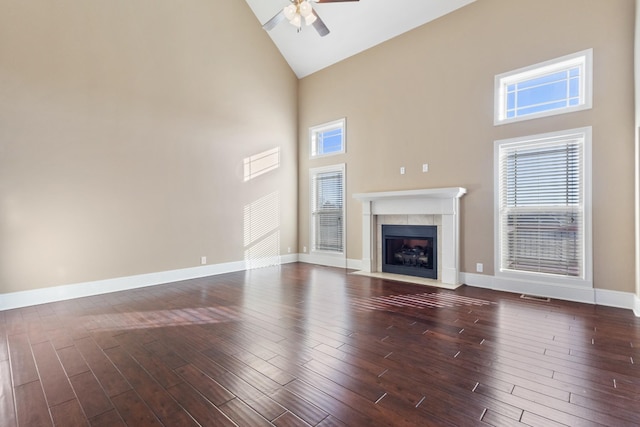 unfurnished living room with dark hardwood / wood-style floors, high vaulted ceiling, and ceiling fan