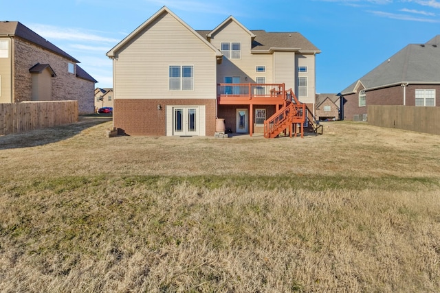 back of property with a lawn and a wooden deck