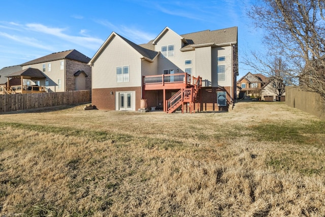 rear view of property featuring a wooden deck and a lawn