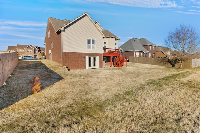 rear view of house with a lawn and a wooden deck