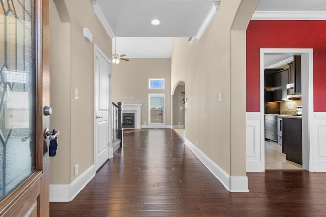 foyer featuring ceiling fan, ornamental molding, and dark wood-type flooring