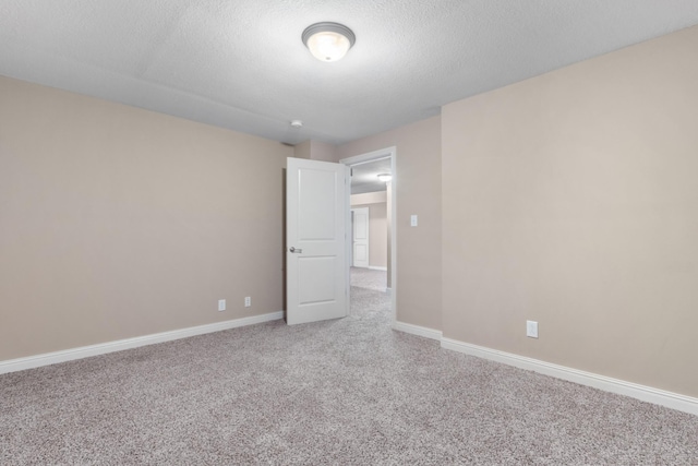 empty room featuring a textured ceiling and carpet