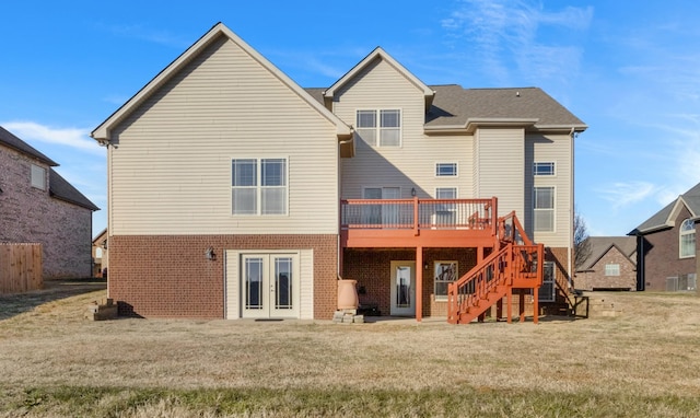 rear view of house featuring a yard, a deck, and french doors