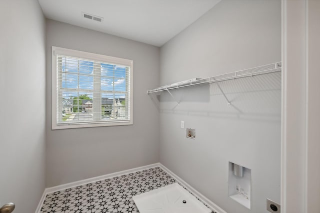 clothes washing area with tile patterned floors, baseboards, washer hookup, and laundry area