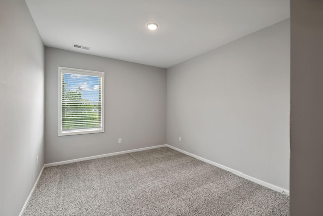 unfurnished room with visible vents, baseboards, and carpet