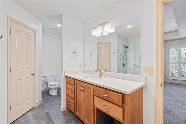 bathroom with a textured ceiling, a shower with door, toilet, and vanity