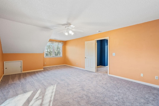 additional living space featuring lofted ceiling, light colored carpet, a textured ceiling, and ceiling fan